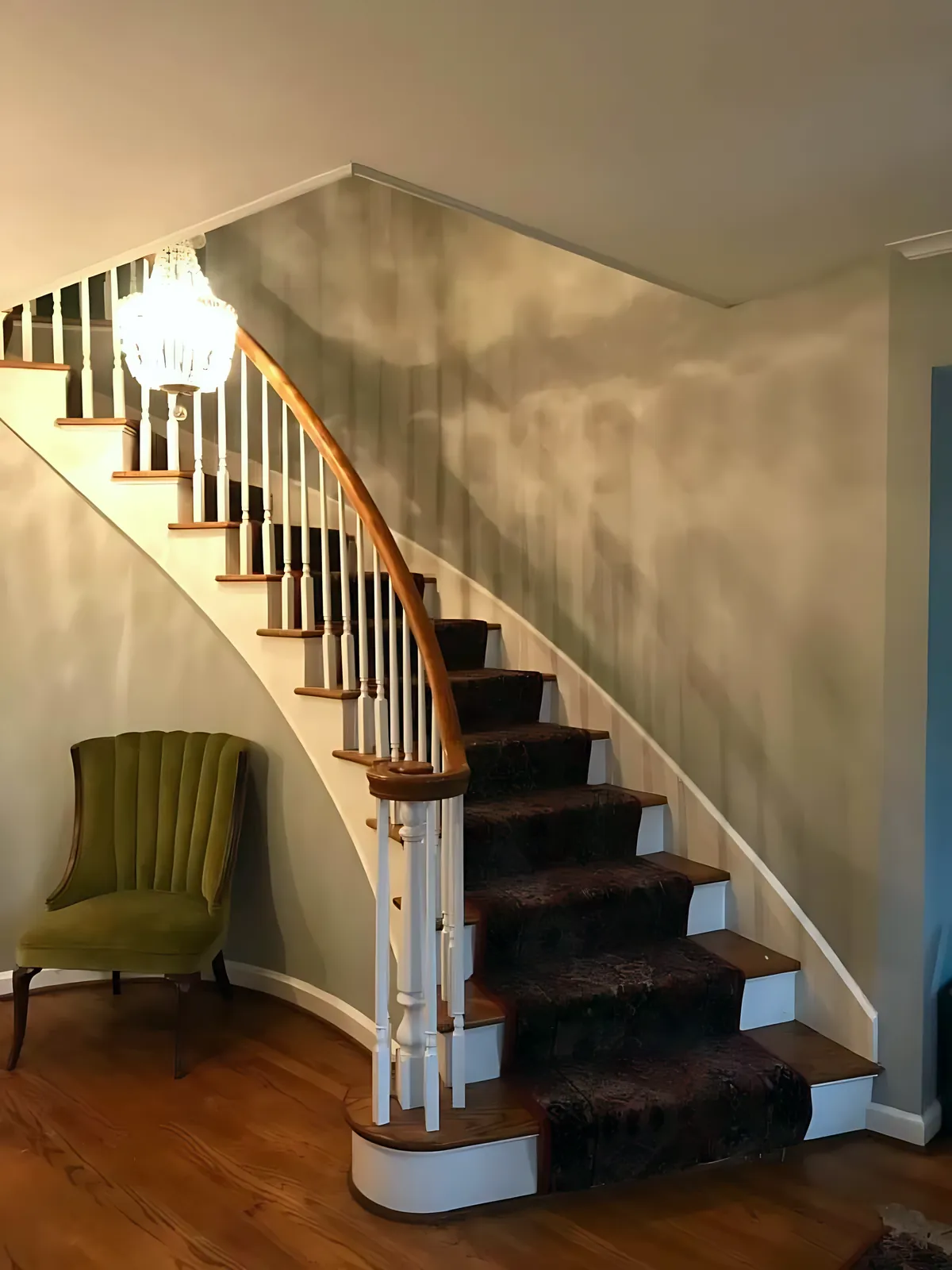 A curved staircase foyer, wallpaper stripped and painted